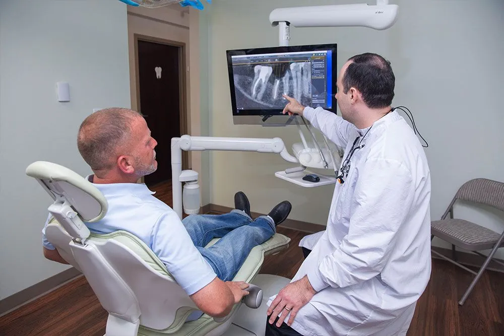 A dentist and patient reviewing a 3D cone-beam x-ray on the operatory monitor at Independence Family Dentistry