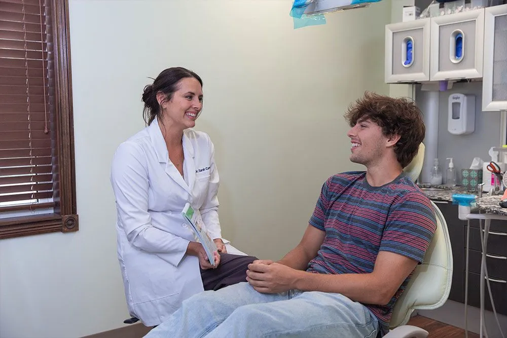 Dr. Carver talking with a young patient in an operatory